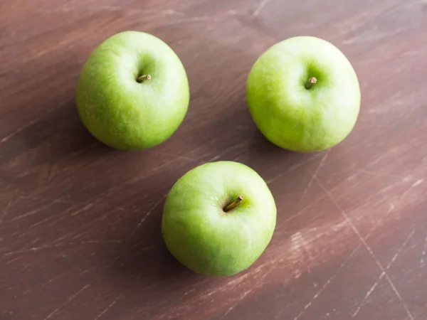 Zelená jablka na dřevěném stole — Stock fotografie