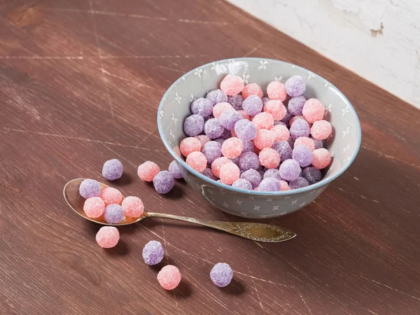 Purple and pink candies on wooden background