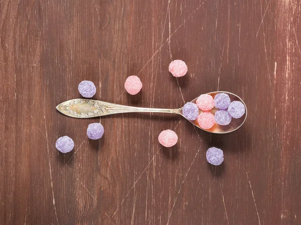 Bonbons violets et roses sur fond en bois — Photo