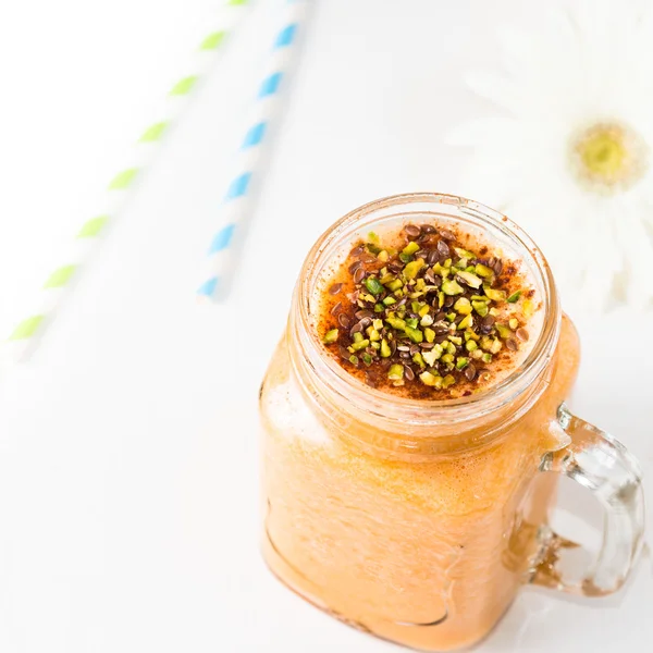 Pumpkin smoothie topped with pistachio nuts and flax seeds