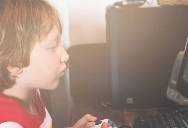 Kleines Kind spielt mit Steuerknüppel vor PC — Stockfoto