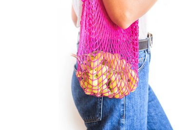 Yeniden kullanılabilir ağ çantalı genç bir kadın.