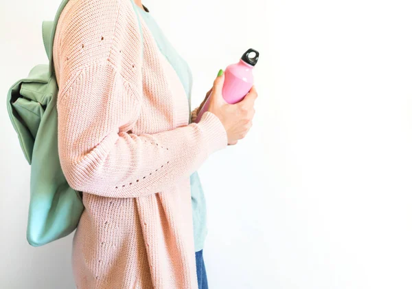 Kvinna i pastell med ryggsäck och återanvändbar flaska — Stockfoto