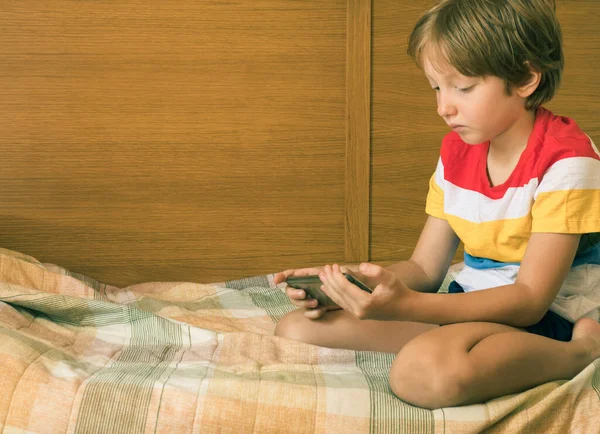 Kleiner blonder Junge spielt Spiele am Smartphone — Stockfoto