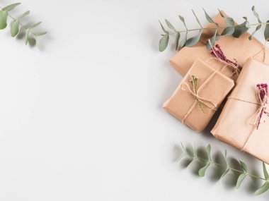 Kurumuş çiçeklerle el işi kağıtlara sarılmış hediye kutuları.