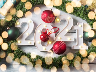 Yeni 2021 yılı beyaz ahşap masada, ışıkları olan.