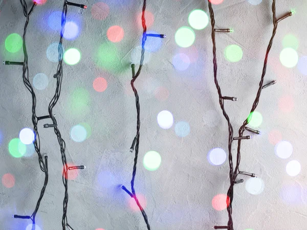 Boże Narodzenie kolorowe świąteczne światła na szarej ścianie — Zdjęcie stockowe