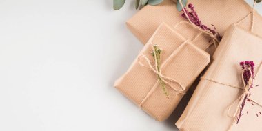 Kurumuş çiçeklerle el işi kağıtlara sarılmış hediye kutuları.