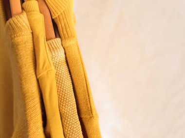 Askılarda sarı renkli kış kazakları.