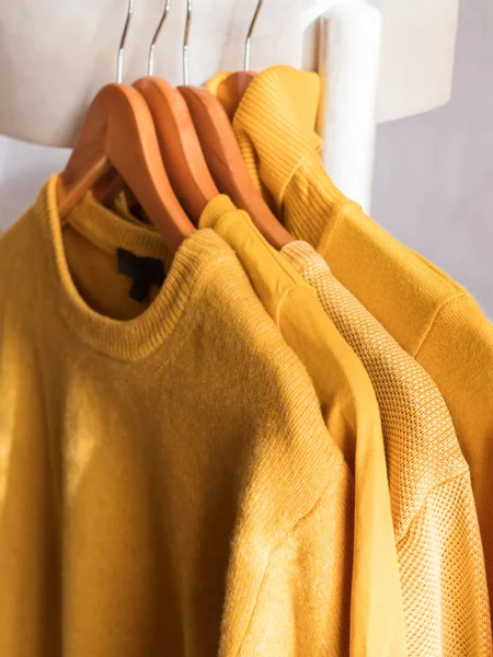Suéteres de invierno de color amarillo iluminado en perchas — Foto de Stock