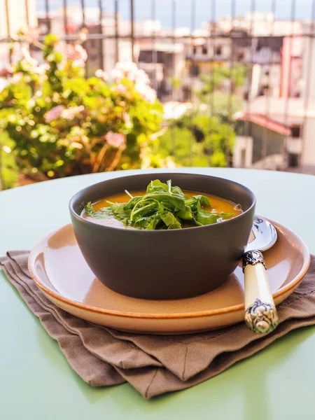 Creamy pumpkin soup served in bowl with arugula — Stock Image Creamy pumpkin soup served in bowl with arugula Stock Image