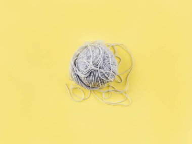 Aydınlatılmış sarı arkaplanda gri yün Hank