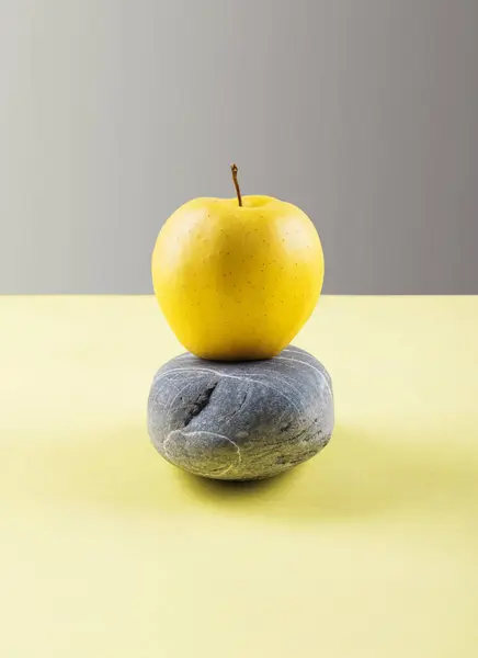 Svítit žluté jablko bilance na kámen tmavě šedá — Stock fotografie