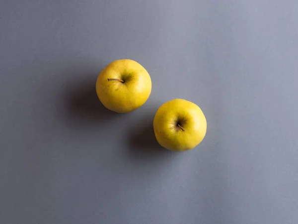 Osvětlená žlutá jablka na tmavě šedém pozadí — Stock fotografie