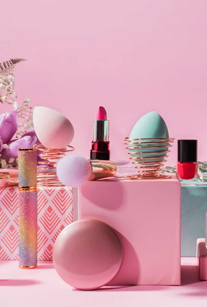 Outils de maquillage, produits sur podiums géométriques sur rose — Photo