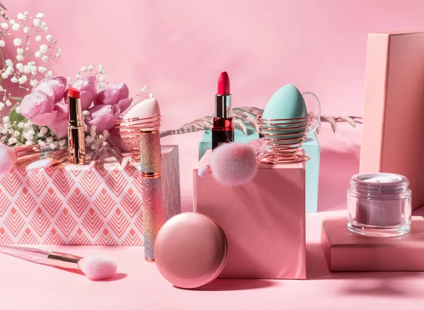 Outils de maquillage, produits sur podiums géométriques sur rose — Photo