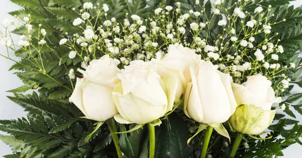 Weiße Rosen Strauß als Geschenk an einem Feiertag auf grau — Stockfoto