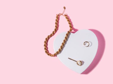 Beyaz kalp şeklinde altın aksesuarları olan moda sevgililer günü arkaplanı.