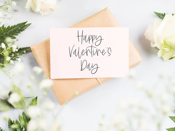 Csomagolt kézműves ajándékdoboz üres rózsaszín kártyával és virágokkal. Boldog Valentin napot! — Stock Fotó