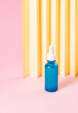 Pembe geometrik arka planda Hyaluronic asit serumu jenerik şişe