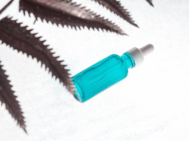 Hyaluronik asit serumu. Beyazın üzerinde odaklanmamış bitkiyle genel şişe tedavisi.