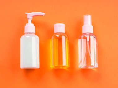 Turuncu arka planda genel güzellik ürünleri.