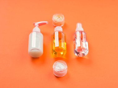 Turuncu arka planda genel güzellik ürünleri.