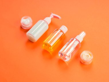 Turuncu arka planda genel güzellik ürünleri.