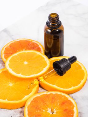 Beyaz mermer kaplamalı C vitamini serumu şişesi.