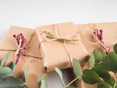 Kurumuş çiçek desenli el işi kağıtlara sarılmış hediye kutuları.