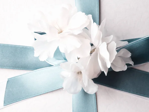 白色礼品盒，用蓝色缎带和装饰花包裹 — 图库照片