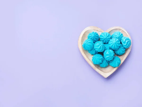 Hartvormige houten schaal met blauwe zoete meringues — Stockfoto