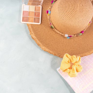 Yazın parlak turkuaz gri taş arka planda güzellik çantası ve hasır şapkayla