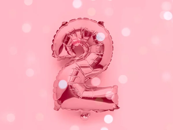 Numero 2 rosa oro foglio decorazione partito palloncino su sfondo rosa, concetto anniversario di compleanno con luci festive — Foto Stock