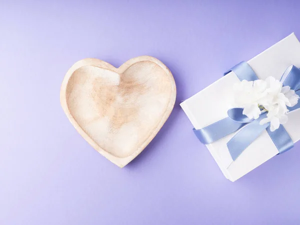 Порожня страва у формі серця та подарункова коробка на фіолетовому. Вітальна листівка — стокове фото