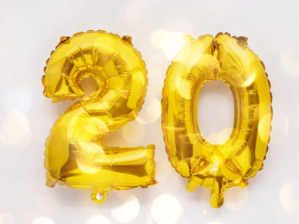 20 golden foil balloon numbers party decor on white background, birthday concept with lights — Stock Photo, Image