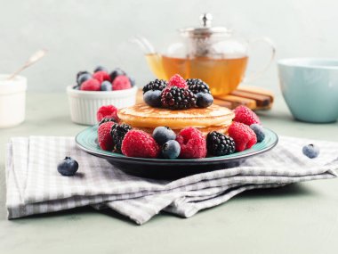 Yaban mersinli krep ve yeşil çayla servis edilen yabanmersinli.