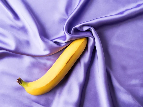 Buruşmuş ipek çarşafta muzlu seksi bir konsept.