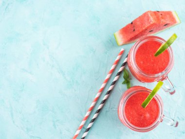 Mavi turkuaz arka planda limon kavanozlu yaz karpuzu smoothie. Üst görünüm