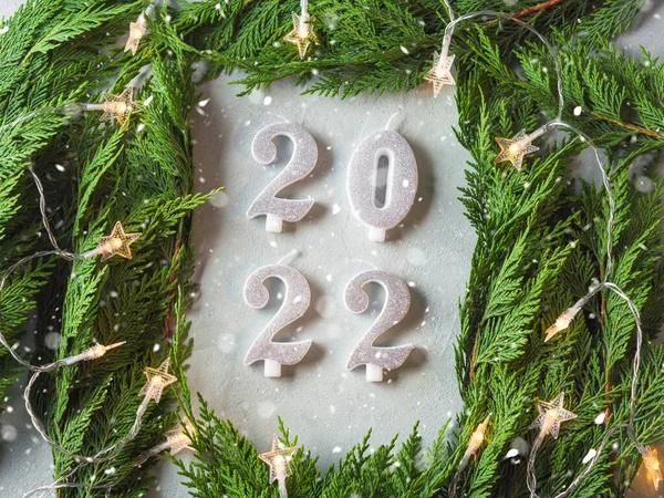 New 2022 year numbers in green branches frame with star shape Christmas lights on gray background — Stock Photo, Image