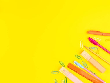 Okul konseptine geri dönelim. Sarı arkaplanda renkli yazma araçları