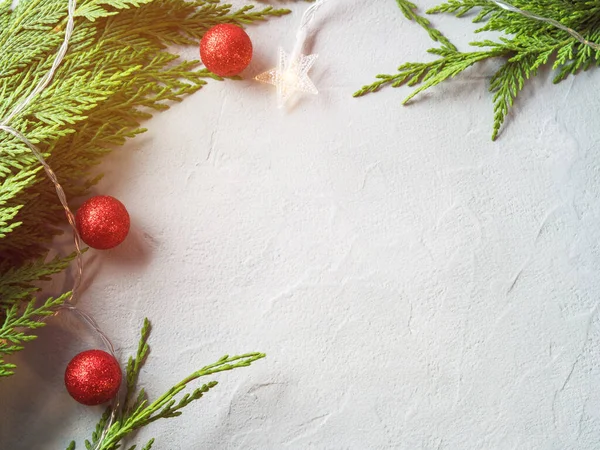 Cadre de branches de sapin vert avec des lumières de Noël en forme d'étoile et un décor d'ornement rouge — Photo