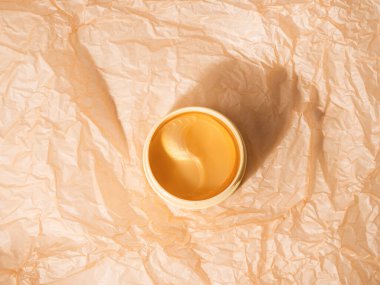 Kırışmış kağıt arka planda plastik kavanozda altın göz bantları