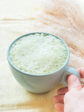 Kibrit çayı, latte sabah antioksidan sıcak içecek mavi bardakta masa örtüsü üzerinde pampa otu