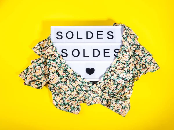 Fashion sale concept with lightbox Spanish text and floral shirt on yellow