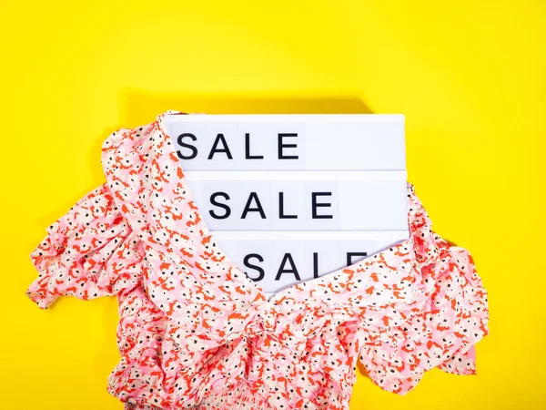 Fashion sale store concept met lightbox tekst en bloemenshirt op gele achtergrond — Stockfoto