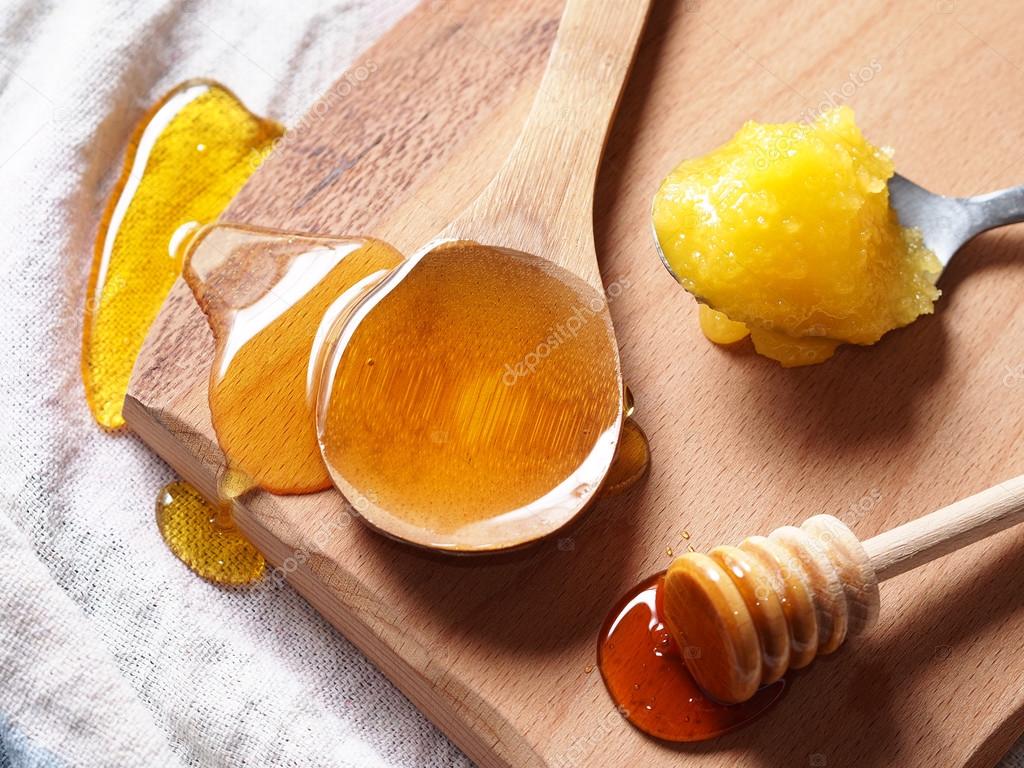 Assortment of honey on wooden chopping board