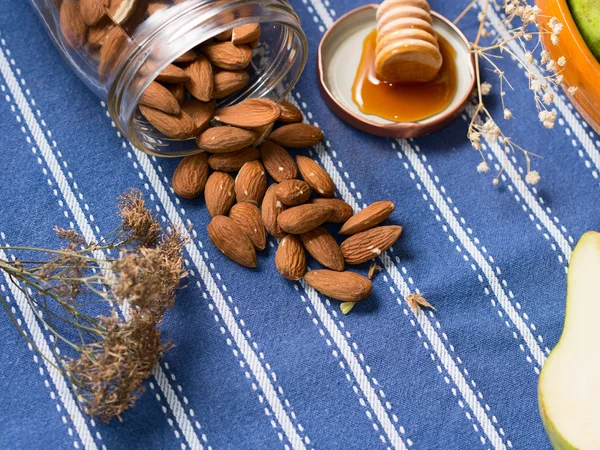 Handful of almonds on blue table cloth — Stock Photo, Image
