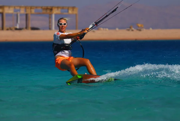yeşilimsi mavi deniz açık gökyüzü altında bir genç kadının uçurtma sörfçü rides