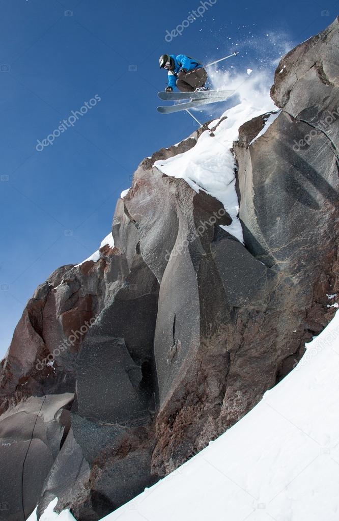 Skier jumping  from high cliff.